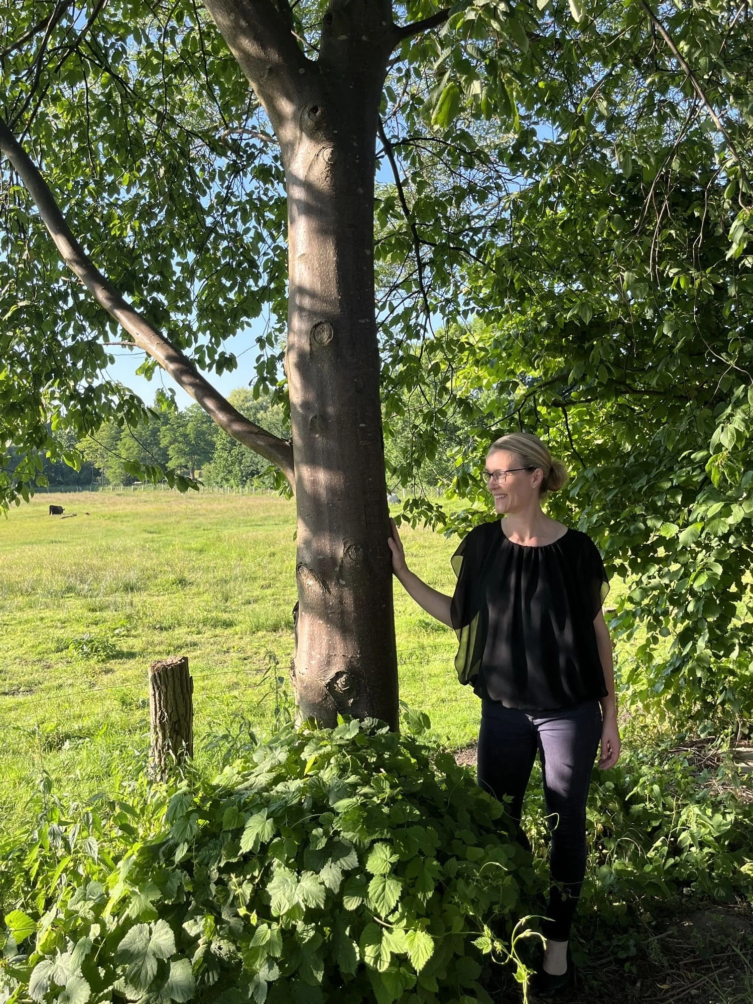 Maike Kreft, systemisches Coaching & Yoga Maike steht neben einem Baum